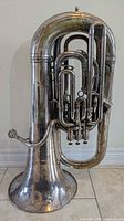 Full view of silver-plated Boosey & Hawkes E-flat tuba standing upright