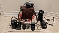 Group shot of camera, bag, lenses, flash, meter, filters, strap, shutter cable