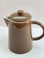 Side view of brown ceramic coffee/tea pot with lid
