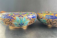 Side view of both cloisonné ashtrays showing exterior enamel patterns