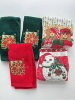 Set of five Christmas-themed hand towels displayed flat