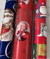 Close-up of three Christmas wrapping paper rolls showing patterns