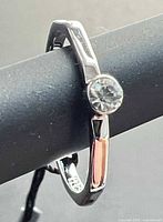 Side view of ring showing bezel-set crystal and band detail