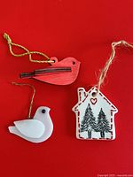 Group shot of three ornaments: wood bird, glass dove, ceramic house