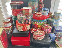 Stacked assortment of decorative tins, various shapes and sizes