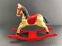 Left side view of painted wooden rocking horse