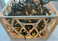 Overall view of plastic crate filled with illuminated white string lights