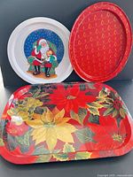 All three metal Christmas-themed trays grouped