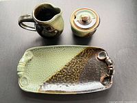 Top view of tray, creamer, sugar bowl with lid showing glazing and form