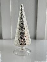 Front view of silver mirrored glass cone tree on clear pedestal base