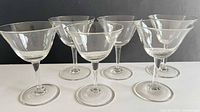 All six matching clear liqueur glasses front view