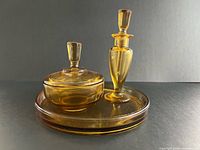 Full vanity set showing perfume bottle with stopper, lidded powder bowl and tray
