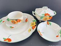 All five ceramic pieces showing floral design