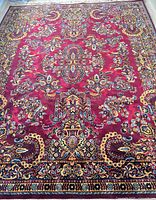 Full view of burgundy oriental rug showing overall pattern and colors