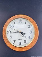 Front view of Daniel Dakota wall clock showing dial and wood frame