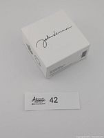 white outer box top view showing John Lennon signature