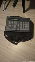 Front view of Roland R-70 drum machine resting on black carrying bag