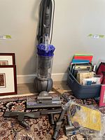 Dyson Ball vacuum with attachments spread on floor
