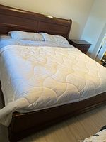 Full view of Durham king sleigh bed with mattress and bedding