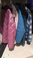 Five jackets hanging on rail showing colours and styles