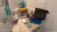 Countertop with Oral-B toothbrush package, blood pressure monitor, bandages, Nexcare and Futuro boxes, organizer and accessories