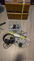 Lot overview showing AKG headphones, bin, and bag with smaller headphones