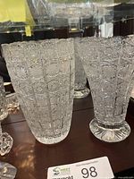 Both cut crystal vases side by side in cabinet