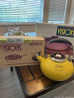 Boxed Visions skillet, boxed casserole, and yellow Chantal kettle on table