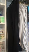 Black pants and white blouse hanging in closet