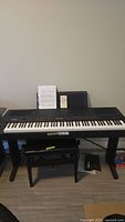 Front view of Yamaha P-250 digital piano on stand with bench beneath