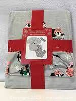Unopened package showing folded pajama set with penguin print