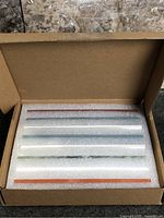 Open box showing eight sharpening stones seated in foam