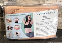 Front of sealed pouch showing castor oil pack wraps and product information