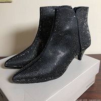 Left side view of jeweled ankle boots on box