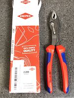 Full view of pliers beside original Knipex box showing branding and part number