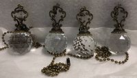 All four crystal pull chains lined up showing prisms, finials and chains