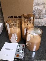 Three glass LED candles, remote, manual, box visible