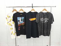Front view of all four T-shirts on hangers
