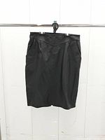 Full front view of black leather pencil skirt on hanger