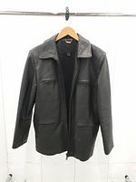 Front view of black leather jacket showing overall design and condition