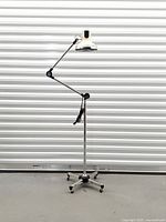 Full view of HKL floor lamp showing articulated arm and castered base