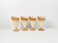 Four cone-shaped frosted glass cups standing in a row