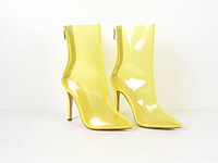 Front angled view of both transparent yellow PVC ankle boots