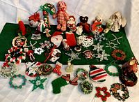 Full assortment of handmade vintage Christmas ornaments spread on green cloth