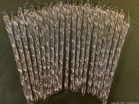 Front view of 21 clear twisted glass icicle ornaments laid out side-by-side