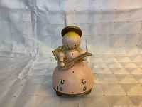 Front view of wooden angel music box holding mandolin