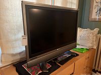 Front view of Sharp 37" LCD TV on stand with remote