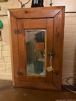 Front view of pine medicine cabinet with mirrored door