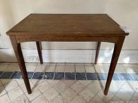Perspective view of wooden side table with tapered legs and arched aprons