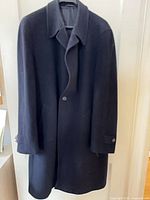 Full front view of navy overcoat on hanger